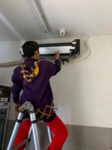 Teknisi soga mandiri teknik sedang melakukan cuci rutin ac
